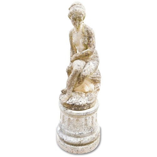 769 - 20th century cast composition stone garden figure of a seated maiden on a concrete circular plinth, ... 