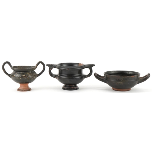 350 - Three Greek black glazed terracotta two handled bowls, circa 400 BC, one with marks to the rim, larg... 