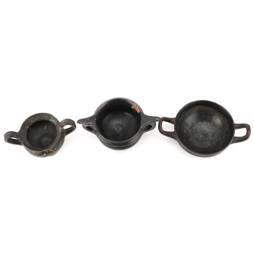 350 - Three Greek black glazed terracotta two handled bowls, circa 400 BC, one with marks to the rim, larg... 