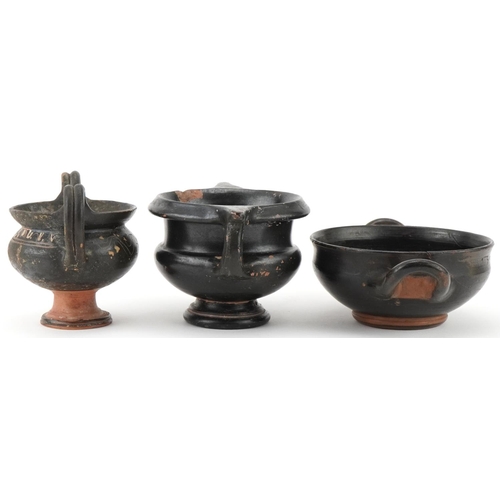 350 - Three Greek black glazed terracotta two handled bowls, circa 400 BC, one with marks to the rim, larg... 