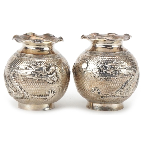 149 - Pair of Chinese export silver globular vases embossed with a dragon chasing a pearl, indistinct mark... 