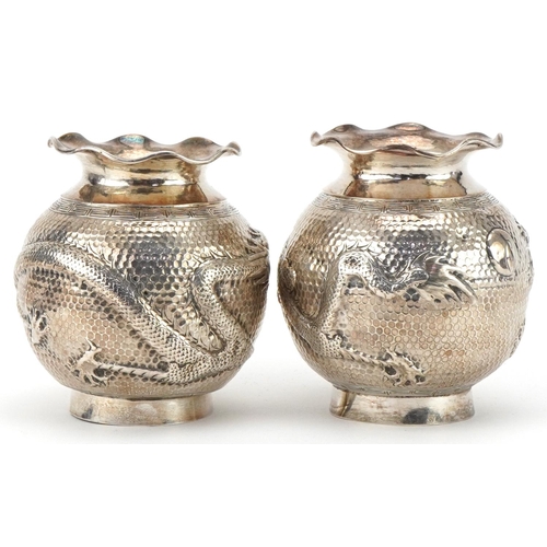 149 - Pair of Chinese export silver globular vases embossed with a dragon chasing a pearl, indistinct mark... 