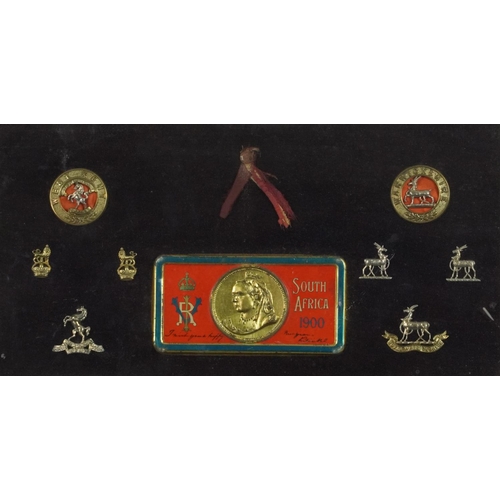 2626 - Military interest cap badges and South Africa 1900 tin lid housed in a glazed frame - West Kent and ... 