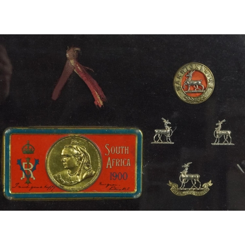 2626 - Military interest cap badges and South Africa 1900 tin lid housed in a glazed frame - West Kent and ... 