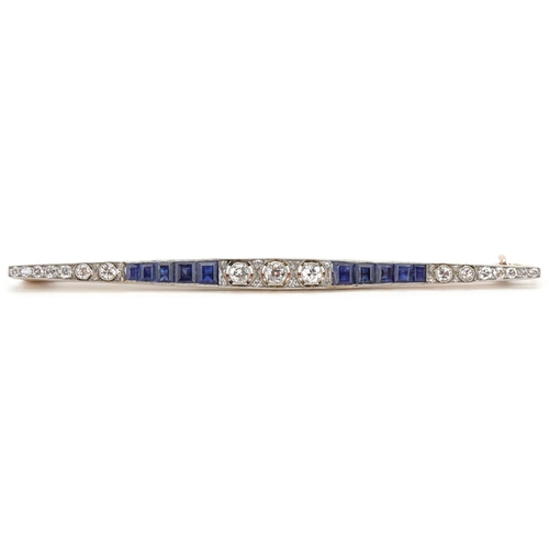 Art Deco gold, diamond and sapphire bar brooch, the three brilliant cut central diamonds interspersed by eight single cut diamonds and five calibré cut graduated sapphires in a Gowland Bros Limited leather fitted box, the diamonds size range approximately 0.02 carat to 0.10 carat, 8cm in length, 5.3g