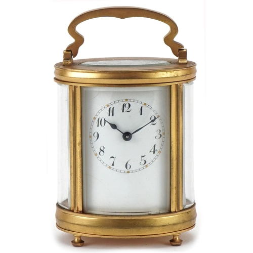 188 - Oval brass and bevelled glass carriage clock having enamelled dial with Arabic numerals, 12cm high