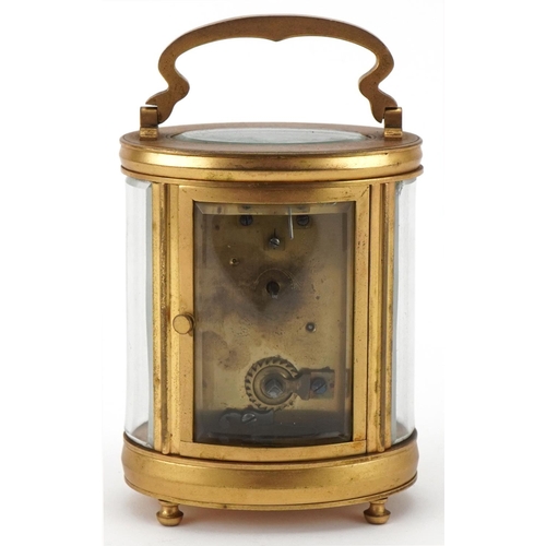 188 - Oval brass and bevelled glass carriage clock having enamelled dial with Arabic numerals, 12cm high