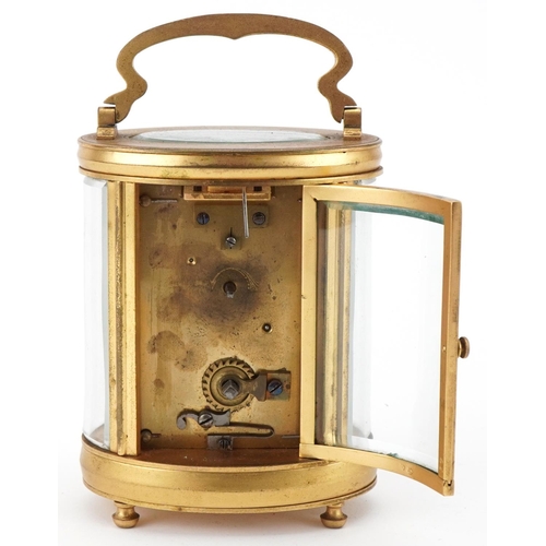 188 - Oval brass and bevelled glass carriage clock having enamelled dial with Arabic numerals, 12cm high