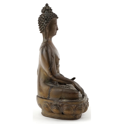 214 - Large Tibetan bronze figure of a Buddha seated on  a lotus throne, 40cm H x 26cm W x 17cm D