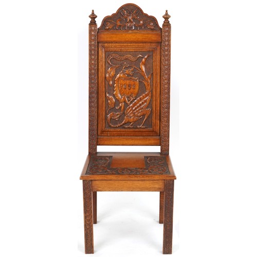 1035 - Victorian oak hall chair heavily carved with a dragon and shield, dated 1898, 120cm high