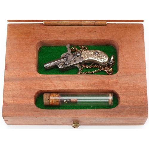 68 - Miniature starting pistol housed in a wooden box, the pistol 4cm in length