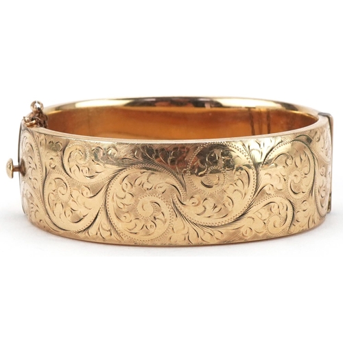 3070 - Large Victorian style 9ct gold metal core hinged bangle engraved with foliage, 2cm high x 6.5cm wide... 