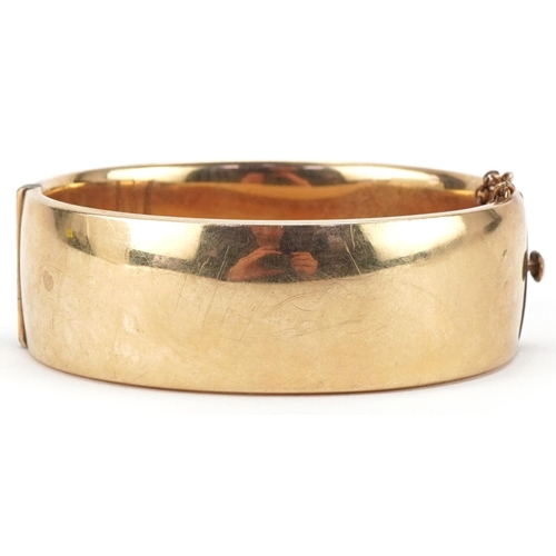 3070 - Large Victorian style 9ct gold metal core hinged bangle engraved with foliage, 2cm high x 6.5cm wide... 