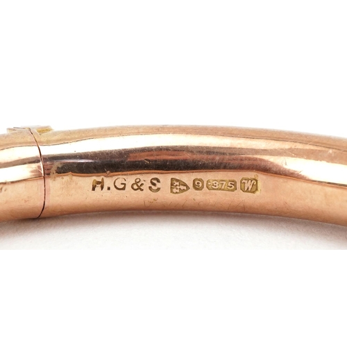 3050 - George V 9ct rose gold hinged bangle engraved with foliage, 7cm wide, 9.4g