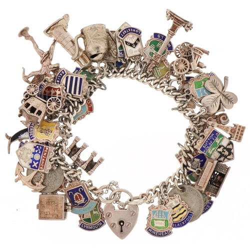 3131 - Silver charm bracelet with a large collection of mostly silver charms including enamelled shield sou... 