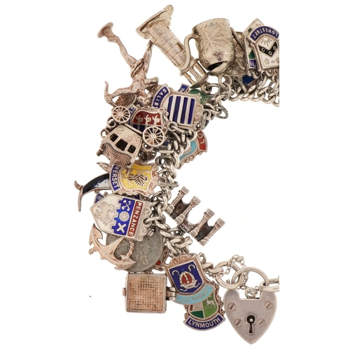 3131 - Silver charm bracelet with a large collection of mostly silver charms including enamelled shield sou... 