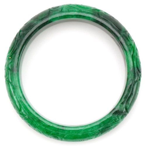 3292 - Chinese carved green jade bangle, 7cm in diameter, 64.0g