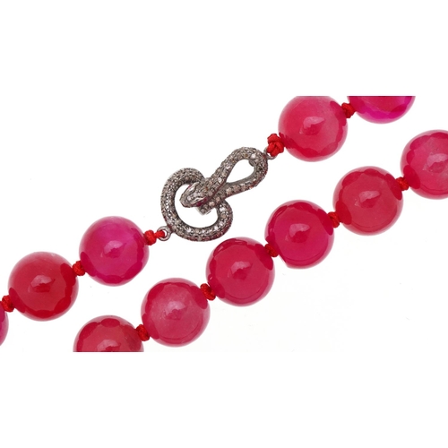  Pink jade bead necklace with white metal clasp in the form of a serpent set with diamonds and rubies... 