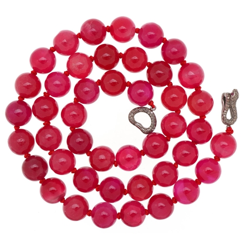 Pink jade bead necklace with white metal clasp in the form of a serpent set with diamonds and rubies, each bead 11.5mm in diameter, overall 58cm in length, 126.8g