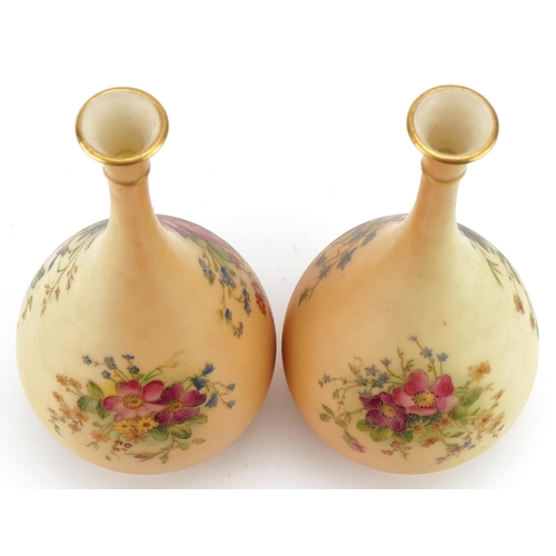 37 - Pair of Royal Worcester floral decorated blush ivory bottle vases, model numbers F105, each 21cm hig... 