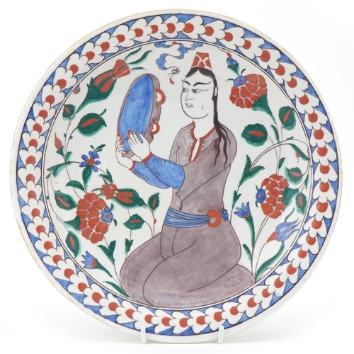 85 - Ottoman Turkish Iznik pottery plate, 20th century, hand painted with a figure and stylized flowers, ... 