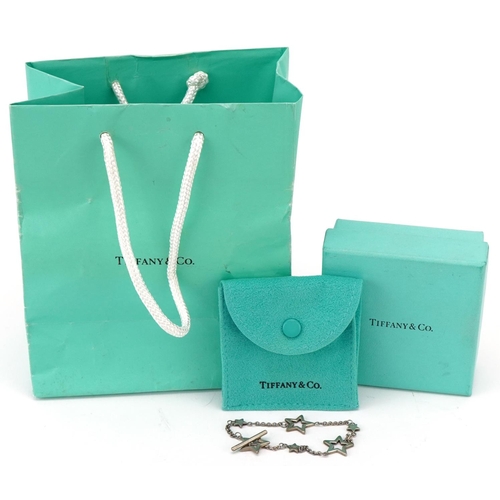 3106 - Tiffany & Co .925 silver bracelet of star link form together with a Tiffany pouch, box and bag.