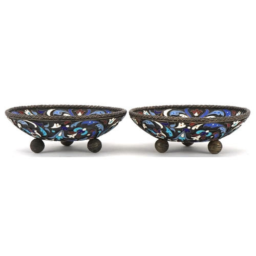 454 - Pair of circular silver and champlevé enamel dishes raised on three ball feet, impressed Russian mar... 