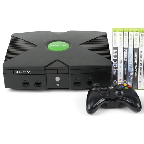 2073 - Two Xbox games consoles with two Xbox controllers and a collection of Xbox 360 games