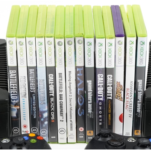 2073 - Two Xbox games consoles with two Xbox controllers and a collection of Xbox 360 games