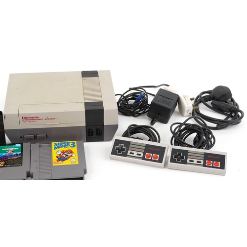 2065 - Nintendo NES version entertainment system with games and controllers, model number NESE-001