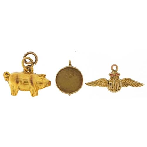 3200 - Three 9ct gold charms comprising pig, RAF wings and a drum, the largest 2cm wide, total 1.9g