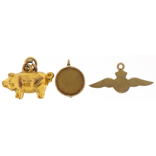 3200 - Three 9ct gold charms comprising pig, RAF wings and a drum, the largest 2cm wide, total 1.9g