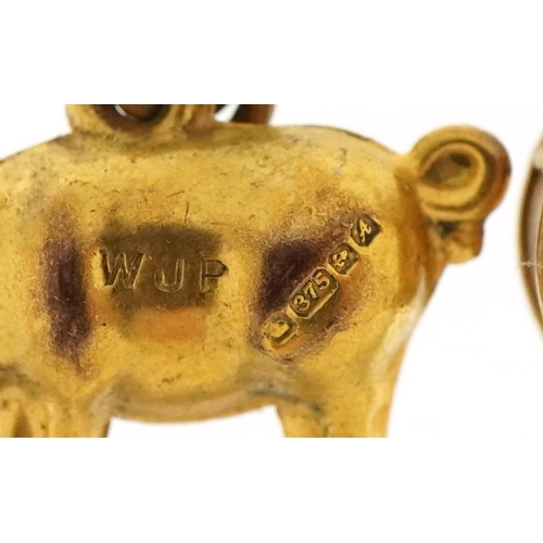 3200 - Three 9ct gold charms comprising pig, RAF wings and a drum, the largest 2cm wide, total 1.9g