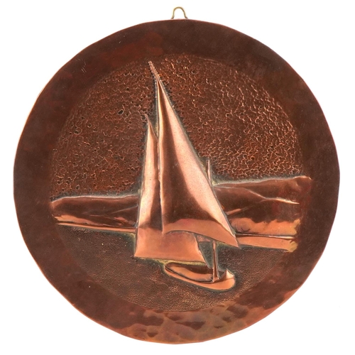 62 - Circular Arts & Crafts copper panel decorated in relief with a boat in full sail, 19cm in diameter