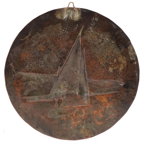 62 - Circular Arts & Crafts copper panel decorated in relief with a boat in full sail, 19cm in diameter