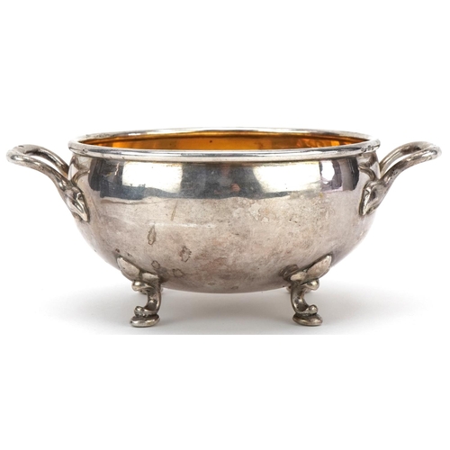 411 - Circular silver twin handled bowl with gilt interior raised on four feet, impressed Russian marks, 1... 