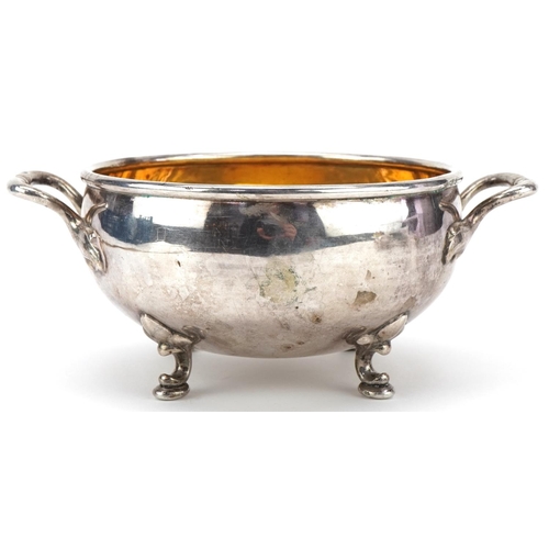 411 - Circular silver twin handled bowl with gilt interior raised on four feet, impressed Russian marks, 1... 