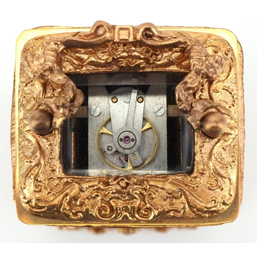 231 - Miniature gilt brass Rococo style carriage clock having enamelled dial with Roman numerals and a swi... 