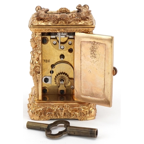 231 - Miniature gilt brass Rococo style carriage clock having enamelled dial with Roman numerals and a swi... 