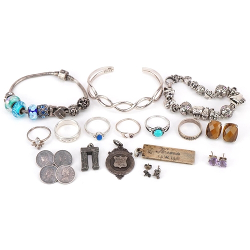 3165 - Silver and white metal jewellery including two charm bracelets, silver ingot pendant, sports jewel, ... 