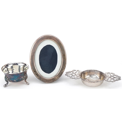 490 - Silver objects comprising twin handled sifter on stand and an oval easel photo frame, the largest 12... 