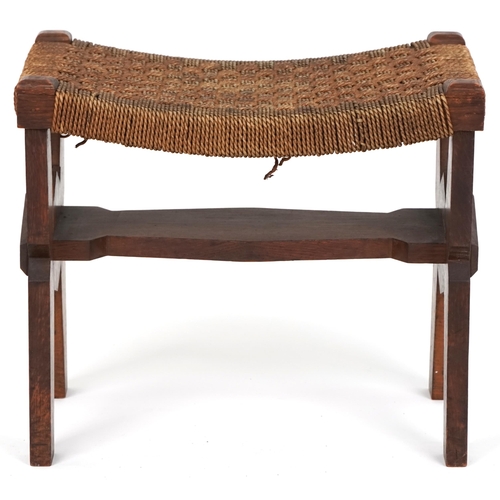 1029 - Early 20th century Arts & Crafts oak stool, the woven string seat raised on shaped supports, 40cm H ... 