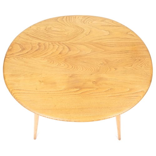 1002 - Ercol elm oval breakfast table raised on four tapering legs united by a newspaper rack, 73cm H x 99c... 