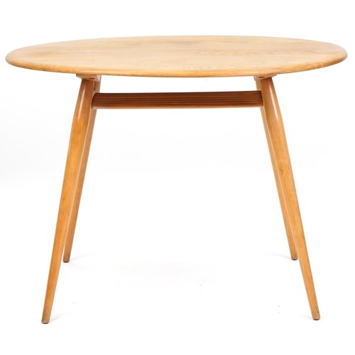 1002 - Ercol elm oval breakfast table raised on four tapering legs united by a newspaper rack, 73cm H x 99c... 