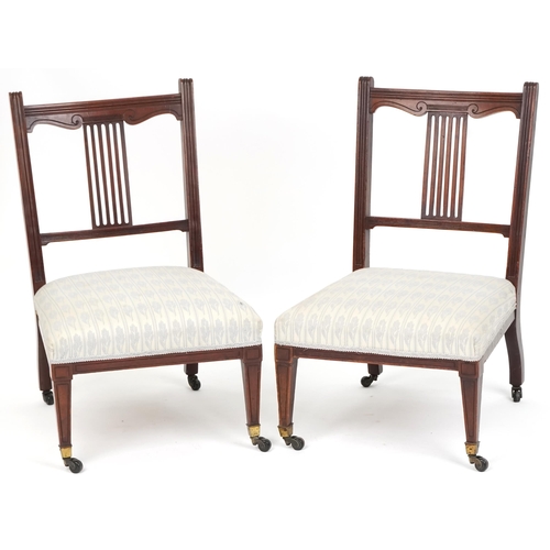 1083 - Pair of Edwardian mahogany nursing chairs with over stuffed seats, raised on tapering legs and caste... 