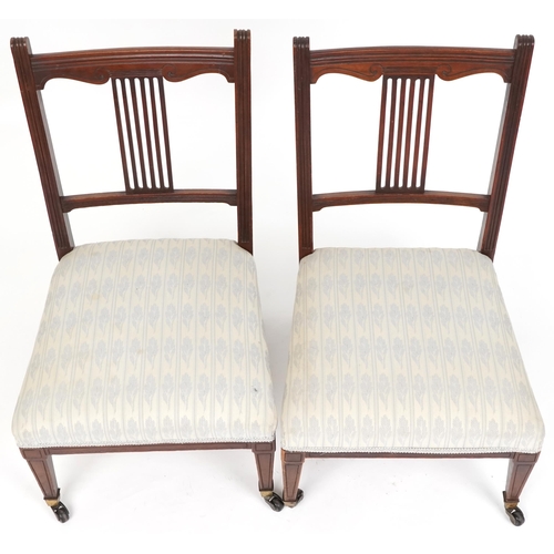 1083 - Pair of Edwardian mahogany nursing chairs with over stuffed seats, raised on tapering legs and caste... 