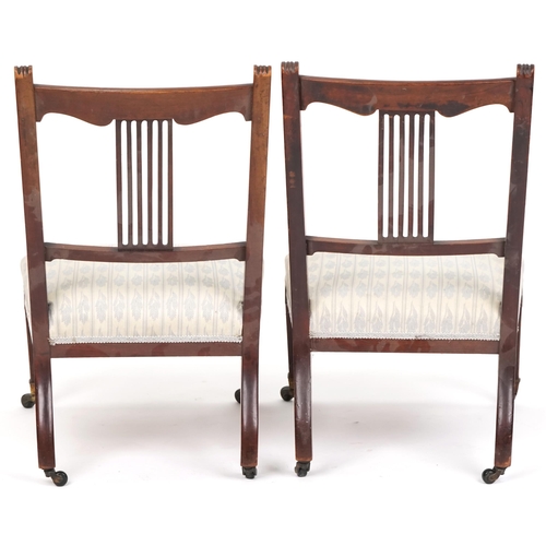 1083 - Pair of Edwardian mahogany nursing chairs with over stuffed seats, raised on tapering legs and caste... 