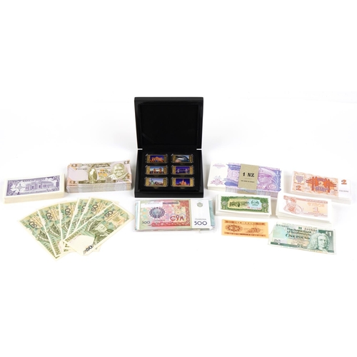 2244 - Quantity of world banknotes in mint condition, many in bundles and a set of six gold plated ingots i... 