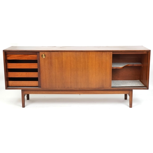 1058 - Mid 20th century teak sideboard, the sliding doors revealing sliding trays to one end, raised on tur... 