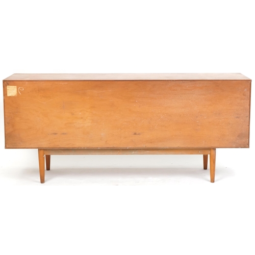 1001 - Mid 20th century teak sideboard, the central door and fall flap flanked by two cupboards on tapering... 